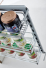 Multi tier pull out pantry basket organizing condiments and jars